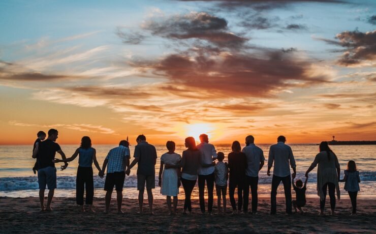 people together on the beach at sunset