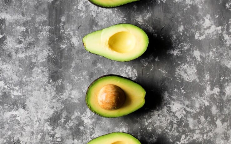 four pieces of avocado cut in half on a table