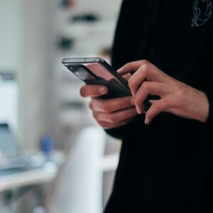 Pessoa segurando um smartphone no escritório