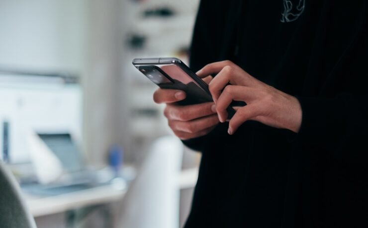 person holding smartphone in hand in office