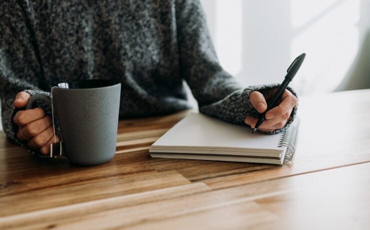 woman holding a pen in her hand about to write a letter