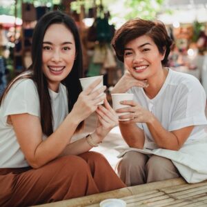 Duas mulheres sorrindo enquanto tomam café