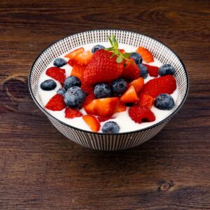 bowl com iogurte e morangos e framboesas e blueberries