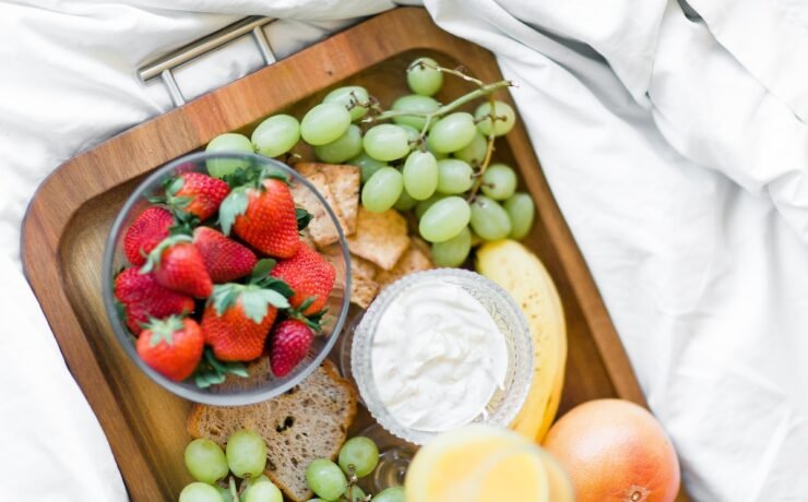 variedade de frutas com iogurte ou queijo sobre bandeja de madeira