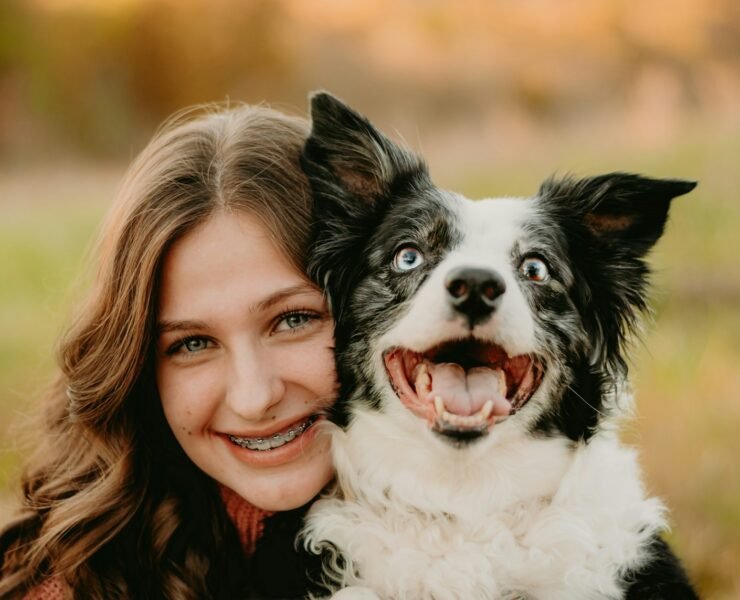 a woman is hugging a dog in a field