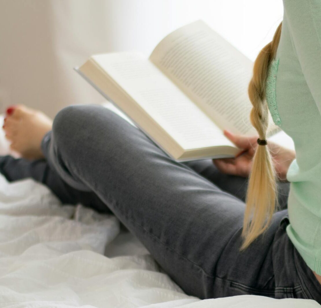 Mulher lendo um livro na cama