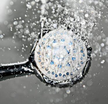 Grande plano de um chuveiro a soltar gotas de água, criando uma cena nítida e refrescante no banheiro