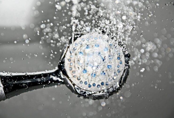 Grande plano de um chuveiro a soltar gotas de água, criando uma cena nítida e refrescante no banheiro