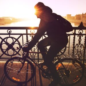 pessoa andando de biciclata em contra luz