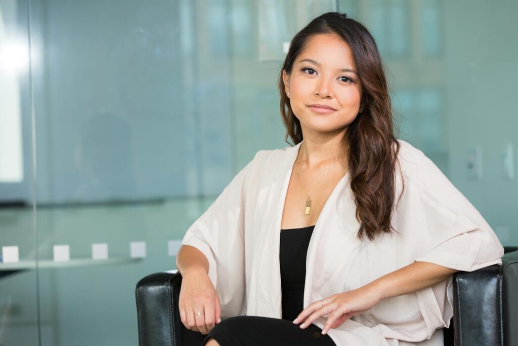 Uma empresária asiática profissional sentada confiantemente em um escritório moderno.