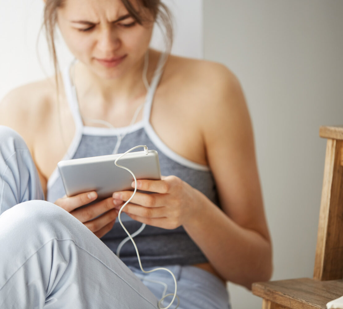 tired woman looking and scrolling at a tablet