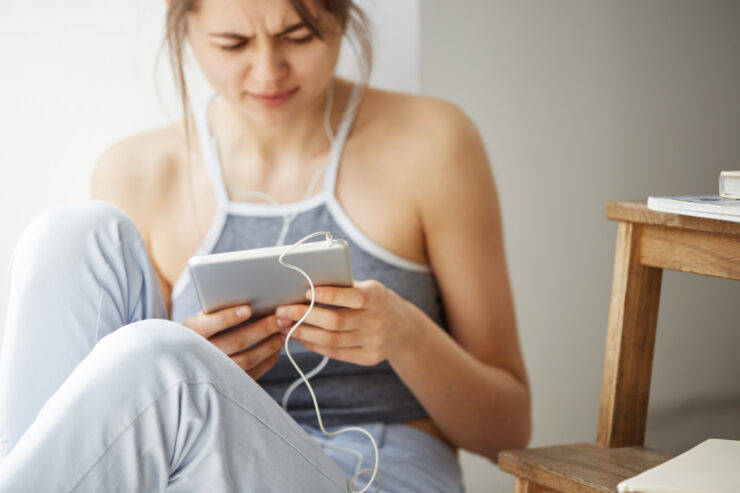 tired woman looking and scrolling at a tablet