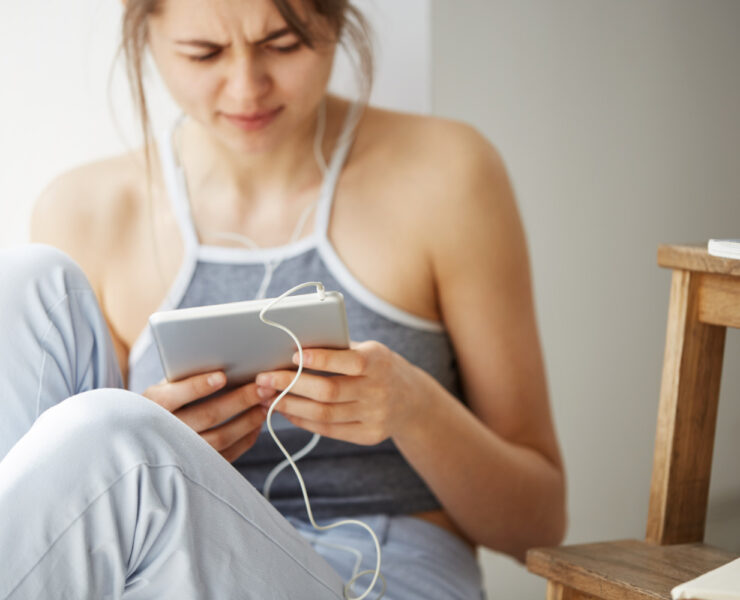 tired woman looking and scrolling at a tablet