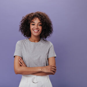 mulher jovem sorrindo de braços cruzados