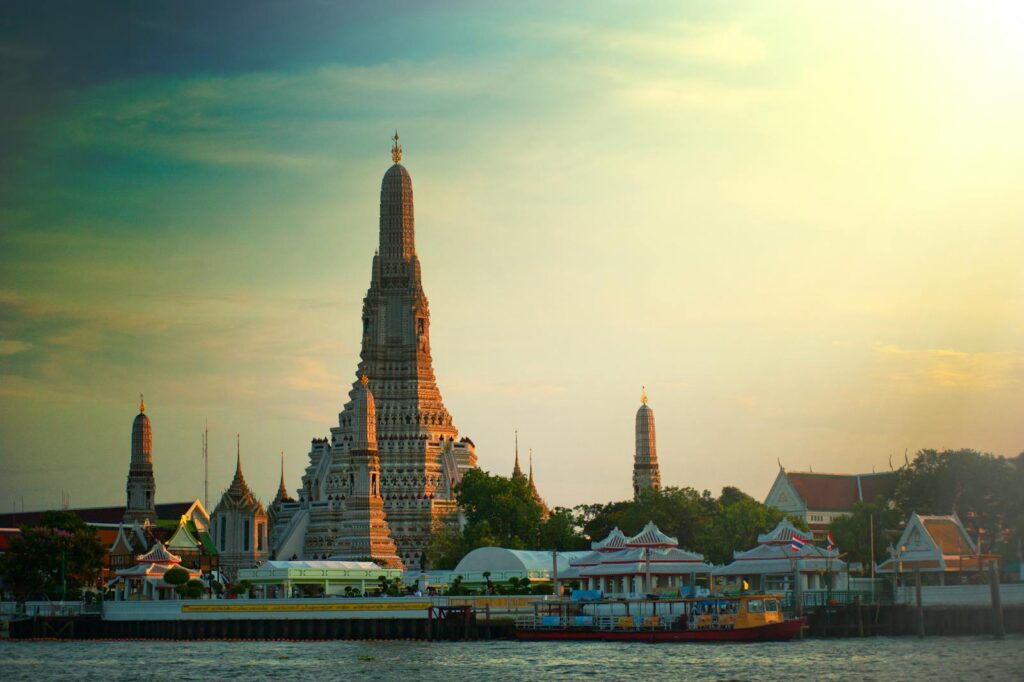 Vista deslumbrante do pôr do sol no templo Wat Arun, às margens do Rio Chao Phraya, em Bangkok, Tailândia.