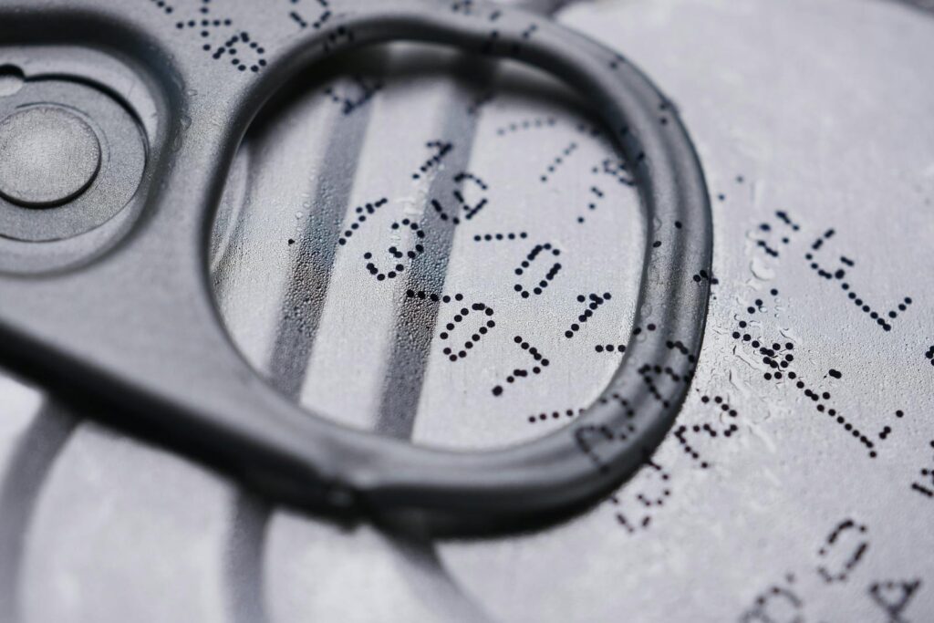 Detailed image of a drink can lid showing printed expiration date.