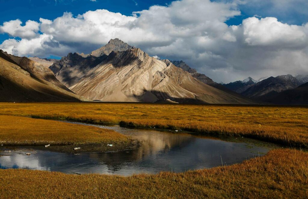 Paisagem deslumbrante de Rangdum, Vale Suru, com montanhas e um lago sob um céu nublado.