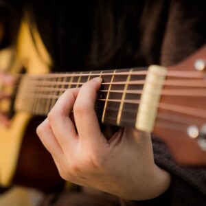 close das mãos de uma pessoa tocando violão