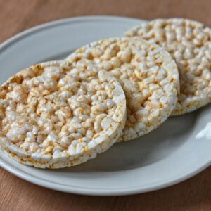A detailed close-up of three puffed rice cakes on a white plate, perfect for food photography.