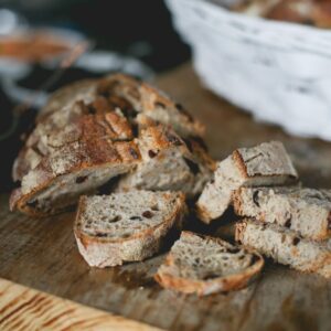 Close-up of freshly sliced artisan bread on a rustic wooden board, perfect for breakfast or snacks.
