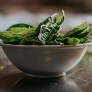 Close-up of fresh spinach leaves in a ceramic bowl, perfect for healthy eating themes.