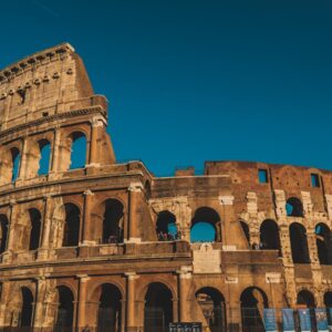 Stunning view of the ancient Roman Colosseum in Rome, Italy, captured at sunset showcasing its historic arches.