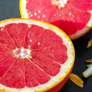 Close-up of juicy grapefruit halves showcasing vibrant red pulp on a dark background.