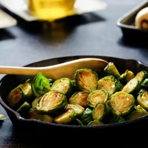 Close-up of delicious roasted Brussels sprouts in a cast iron skillet, perfect for a healthy meal.