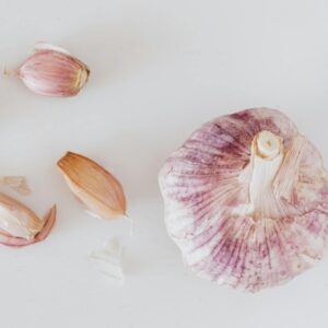 From above closeup of big whole garlic and set of cloves placed on white surface