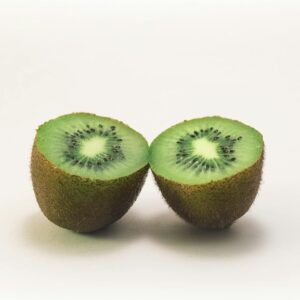 Close-up of two fresh kiwi halves displaying vibrant green color and texture, highlighting freshness and nutrition.