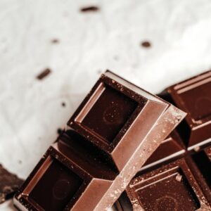 High-quality close-up image of dark chocolate bars on a textured surface, showcasing smooth and glossy textures.