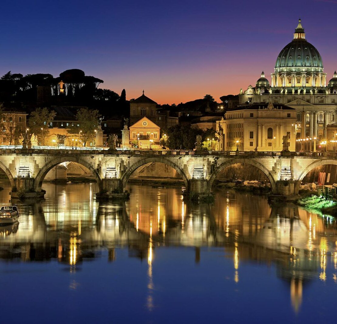 Hermosa vista de la Basílica de San Pedro y el Puente de San Ángel en Roma al atardecer reflejándose en el río Tíber.