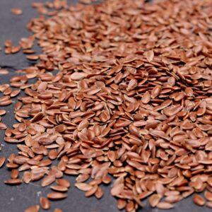 High-resolution close-up of nutritious flaxseeds scattered on a dark background, perfect for health and diet concepts.