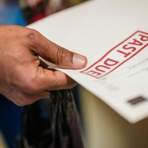 mão segurando um documento com o carimbo "Vencido", destacando a urgência