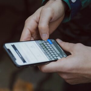 pessoa segurando e digitando em um smartphone