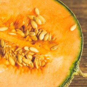 Vibrant close-up of a sliced cantaloupe displaying its fresh orange pulp and seeds.