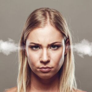 mulher de cara feia com fumaça saindo das orelhas