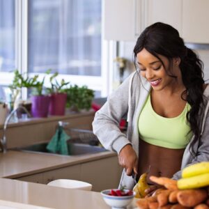 young woman cutting pear in the kitchen smile