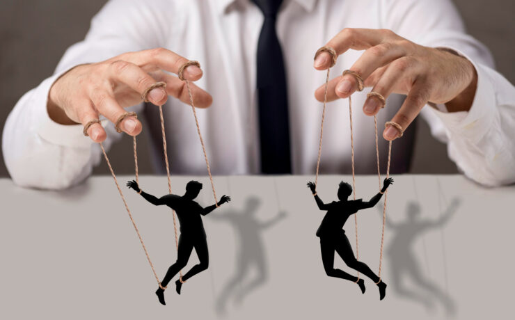 homem manipulando marionetes