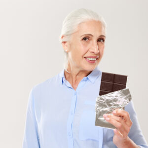 senior woman eating chocolate