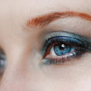 um close do olho de uma mulher com sombra azul