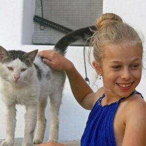 uma jovem está acariciando um gato lá fora
