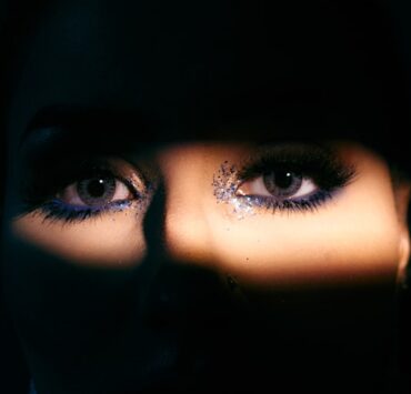 o rosto de uma mulher é iluminado pela luz de uma lanterna mostrando os olhos
