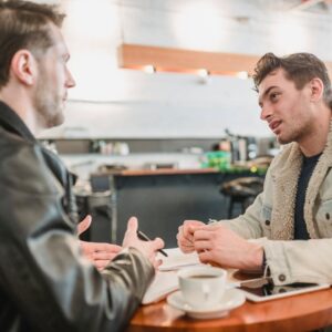 dois homens amigos conversando em um café