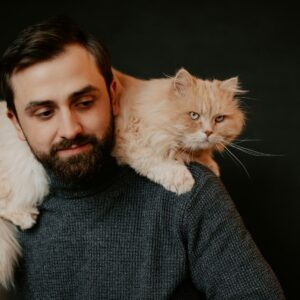 homem com um gato nos ombros