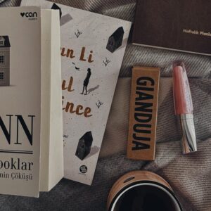Flat lay of books, candles, and stationery for a cozy, study atmosphere.