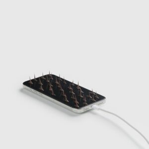 um smartphone carregando cheio de espinhos de rosas sobre ele