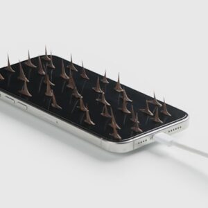 um smartphone carregando cheio de espinhos de rosas sobre ele