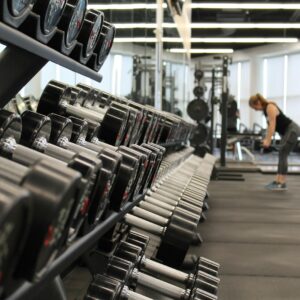 mulher cercada de aparelhos de academia, fitness
