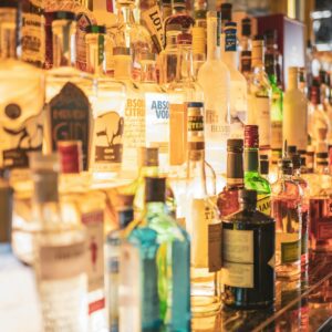 uma prateleira repleta de garrafas de bebidas alcoólicas